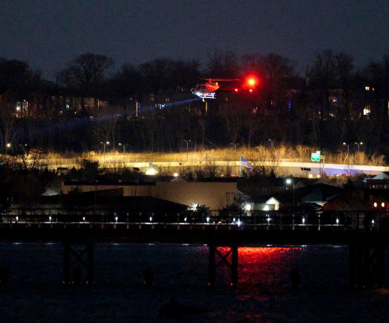 A helicopter assists with search and rescue operations over the Potomac River near Ronald Reagan Washington Airport. Credit: Chip Somodevilla/Getty Images